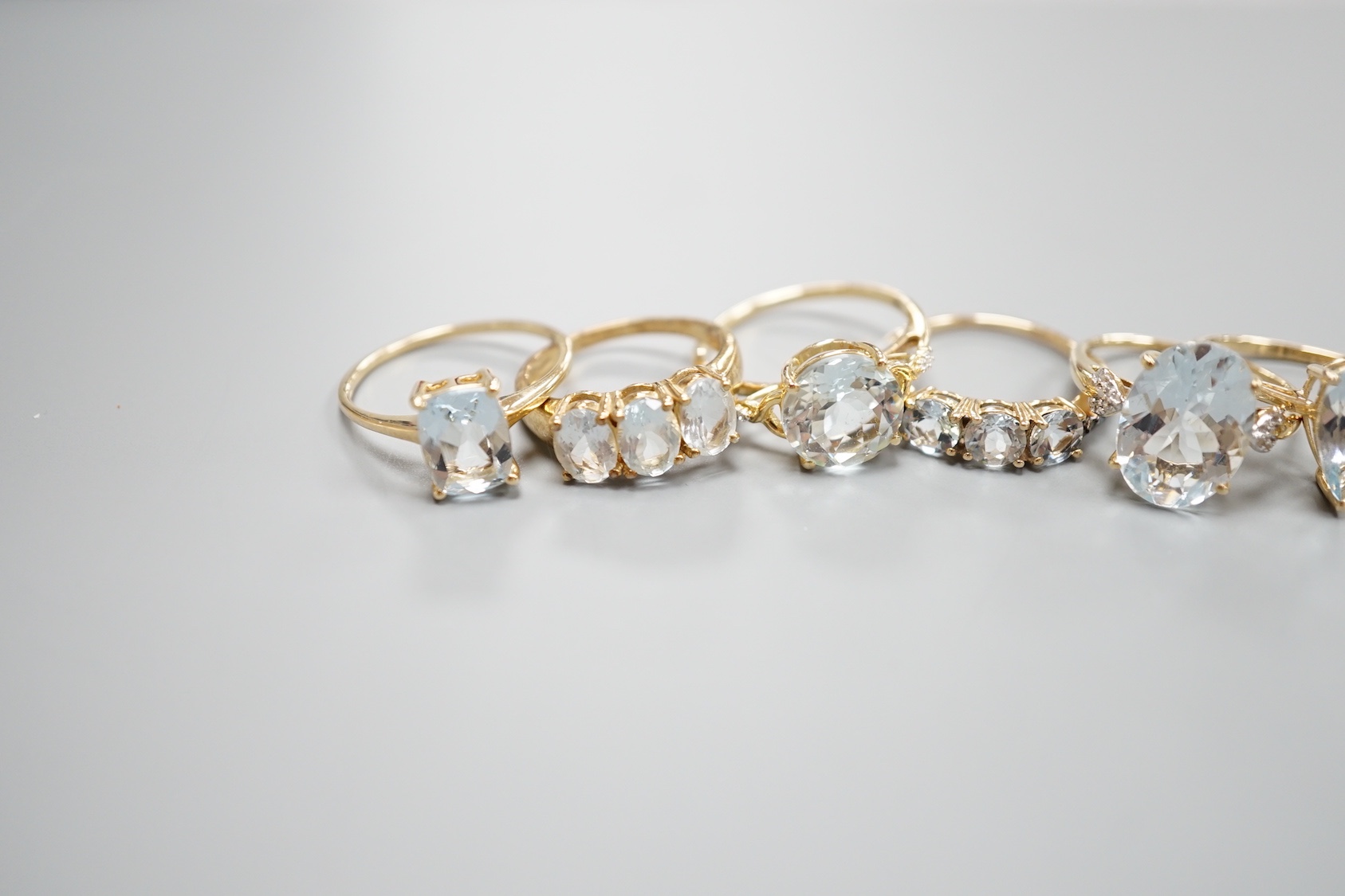 Five assorted modern 9ct gold and aquamarine set dress rings , gross 11.4 grams and one 925 ring.